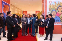 Deputy General Director of the Vietnam News Agency (VNA) Nguyen Thi Su introduces the VNA photo exhibition area at the 11th National Patriotic Emulation Congress to Vice State President Vo Thi Anh Xuan. (Photo: VNA)