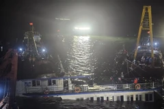 At 2:00 a.m. on July 20, rescue teams begin pumping water out of the capsized tourist boat before towing it ashore. (Photo: VNA)