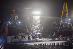 At 2:00 a.m. on July 20, rescue teams begin pumping water out of the capsized tourist boat before towing it ashore. (Photo: VNA)