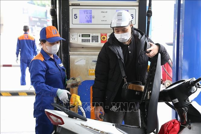 A motorcyclist has his vehicle refilled at a Petrolimex station. (Photo: VNA)