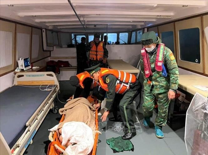 Quang Ninh border guards assist in bringing Japanese tourist Kosuge Kimiko safely ashore for emergency treatment after she suffered a stroke. (Photo: VNA) 