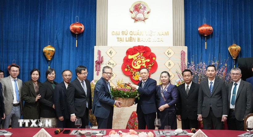 Vietnamese Ambassador Dang Minh Khoi and Lao Ambassador Shiphandone Oybuabuddy with officials and staff of the two embassies. (Photo: VNA) 
