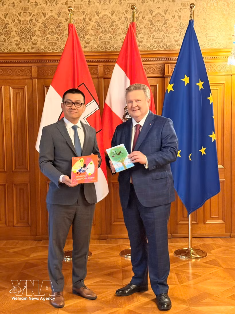Ambassador Vu Le Thai Hoang (L) presents Mayor of Vienna Michael Ludwig with the Vietnamese translation of Austrian author Mira Lobe's children's classic "Grandmother in the Apple Tree". (Photo: VNA) 