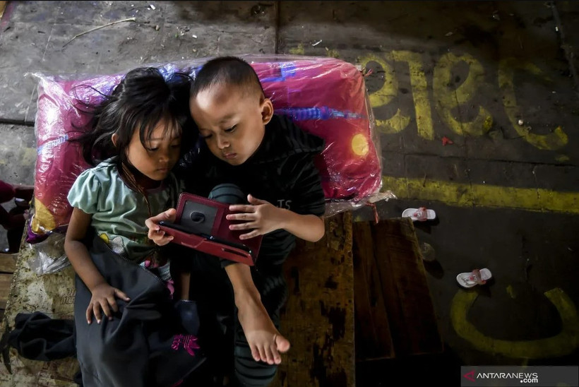 Two children play with a gadget in Jakarta. (Photo: ANTARA)