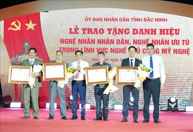 Leaders of the Ministry of Industry and Trade and the Bac Ninh Department of Industry and Trade present the title of Meritorious Artisan to outstanding individuals. (Photo: VNA) 