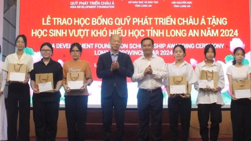 Nguyen Van Duoc, Secretary of the provincial Party Committee and Chairman of the Long An People's Council; Kim Joon Il, Chairman of COBI Group and ADF; and students at the ceremony. (Photo: VNA)