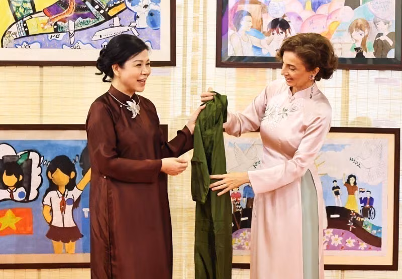 Madam Ngo Phuong Ly (L) presents a traditional Vietnamese Ao dai (long dress) to UNESCO Director-General Audrey Azoulay. (Photo: VNA)