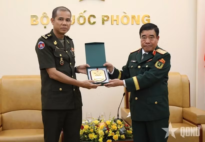Major General Nguyen Ba Luc (R) presents a gift to Lieutenant General Nim Balene. (Photo: Qdnd.vn)