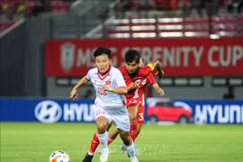 Players of both teams strive to gain possession of the ball. (Photo: VNA)