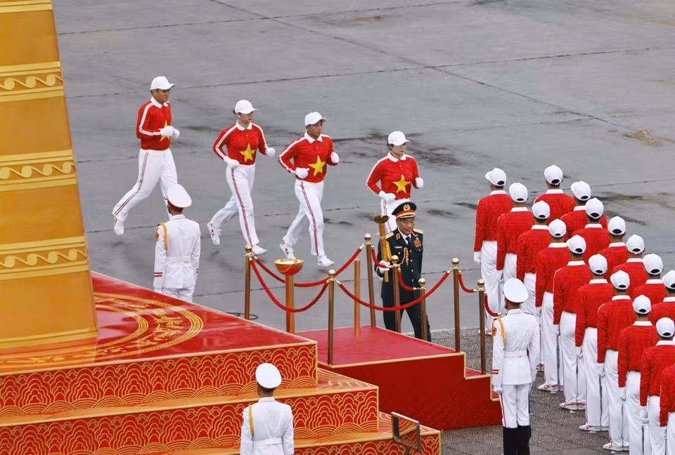 The program begins with the torch relay and the lighting of the ceremonial flame — a symbol of the aspirations of the Vietnamese people. The flame is handed to Lieutenant General Nguyen Duc Soat, Hero of the People’s Armed Forces and former Deputy Chief of the General Staff of the Vietnam People’s Army, who achieved outstanding feats by shooting down six enemy aircraft, becoming one of the heroic pilots of the Vietnam People’s Army. (Photo: Doan Tan - VNA)
