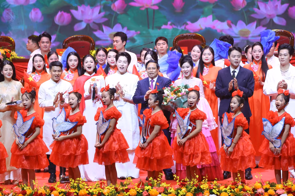 Politburo member, Secretary of the Party Committee, and Prime Minister Pham Minh Chinh presents flowers to artists performing at the Congress’s opening ceremony. (Photo: Van Diep - VNA)