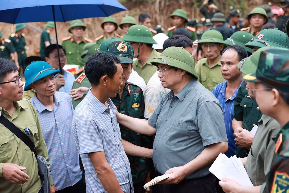 Prime Minister Pham Minh Chinh speaks with residents of Xa Dung commune affected by flooding. (Photo: VNA)