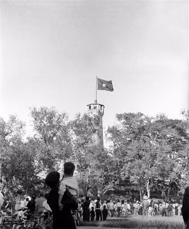 Hanoians joyfully look up at the national flag flying proudly over the Hanoi Flag Tower on the Liberation Day, October 10, 1954. (File photo: VNA)