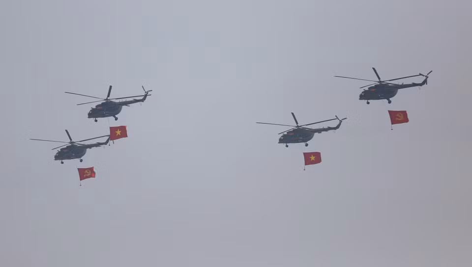 Flying in a 3-4-3 formation, helicopters carry both the Party flag and the national flag. (Photo: VNA)