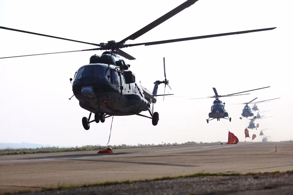 The full squadron of 10 helicopters takes off in unison for a coordinated practice. (Photo: VNA)