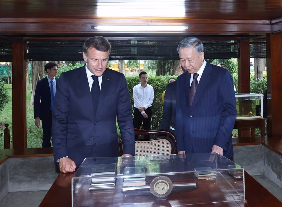 Party General Secretary To Lam and French President Emmanuel Macron visit President Ho Chi Minh's stilt house within the Ho Chi Minh Memorial Site. (Photo: VNA)