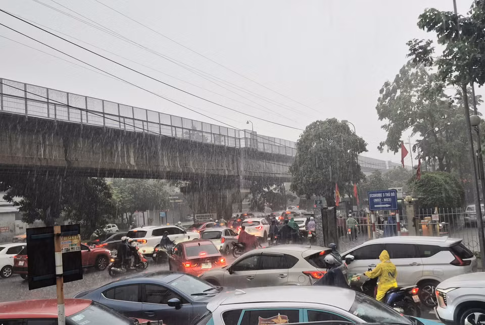 Heavy rain flooding several spots on Tan Xuan street, causing localised traffic congestion. (Photo: VNA)