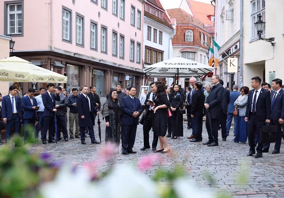 Prime Minister Pham Minh Chinh and his spouse are introduced about the history of Tallinn Old Town. (Photo: VNA)
