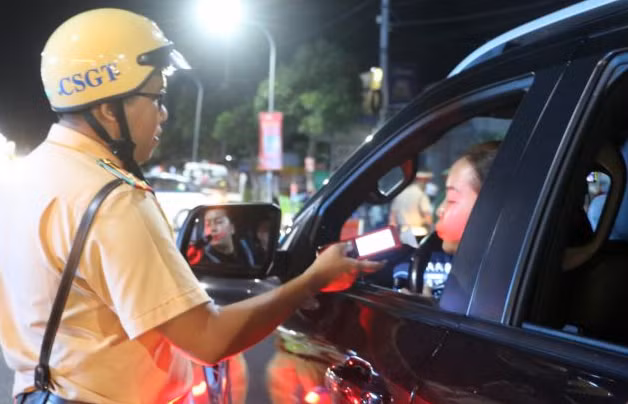 A police officer in Long Xuyen city, An Giang province, check alcohol levels of a driver. (Photo: VNA)