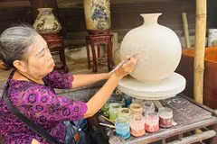 An artisan from Bat Trang Village demonstrates part of the ceramic making process. (Photo: baovanhoa.vn)