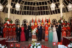 General Secretary of the Communist Party of Vietnam Central Committee and President To Lam (8th from left, first row) and his spouse Ngo Phuong Ly, and Swiss President Guy Parmelin and his spouse Caroline Parmelin present flowers to artists performing at the banquet. (Photo: VNA)