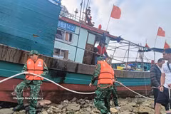 Officers and soldiers of the Hai Phong Border Guard assist a Chinese fishing vessel in securing its moorings while awaiting favourable weather conditions for being towed into the harbour shelter. (Photo: VNA)