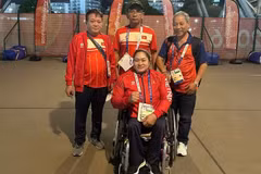 Nguyen Thi Ngoc Thuy with her coach and representatives of the Vietnamese delegation. (Photo: Vietnam Paralympic Committee)