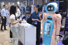 Visitors learn about a robot model designed to care for the elderly at Qualcomm’s booth. (Photo: VNA)