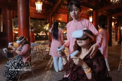 Tourists experience writing calligraphy through virtual reality at Hanoi's Temple of Literature. (Photo: VNA