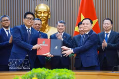 Prime Minister Le Minh Hung (C) witnesses the exchange of the Strategic Alliance Agreement between Petrovietnam and PETRONAS. (Photo: VNA)