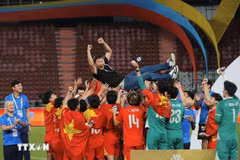 Vietnamese players share their joy with head coach Kim Sang-sik after the win on December 18. (Photo: VNA)