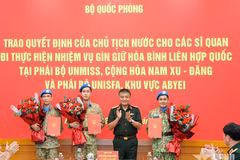 Senior Lieutenant General Nguyen Van Hien presents the President’s decisions to three officers assigned to UN peacekeeping missions. (Photo: qdnd.vn)
