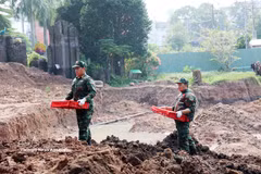 Soldiers bring martyrs’ remains from an excavation site at Le Thi Rieng Park to the room for sample collection and storage for identification. (Photo: VNA)