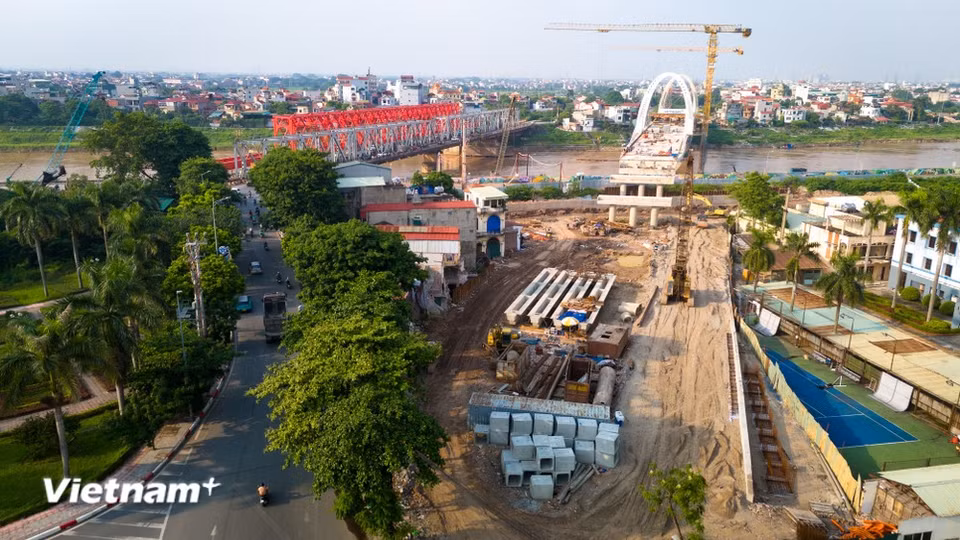 At both ends of the bridge, in Viet Hung Ward and Phu Dong Commune, site clearance has been completed. Machinery and workers are stepping up construction of the approach roads and connecting infrastructure. (Photo: VietnamPlus)