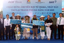 The organising committee presents flowers and gifts to lucky passengers boarding the Osaka – Da Nang flight at the welcome ceremony. (Photo: VNA) 