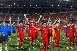 Vietnamese players celebrate with fans. (Photo: VNA) 