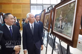 Khamphan Pheuiyavong, Politburo member and Head of the Lao Party Central Committee’s Propaganda and Training Commission, and delegates visit the exhibition. (Photo: VNA) 