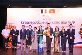 Leaders of HUFO and IDECAF present flowers to congratulate Etienne Ranaivoson, Consul General of France in Ho Chi Minh City, on the country's Bastille Day. (Photo: VNA)