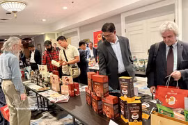Canadian importers view Vietnamese coffee and cocoa products at a trade promotion event in Canada. (Photo: VNA)