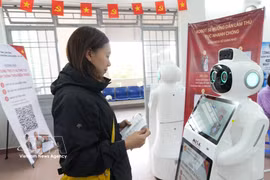 A citizen interacts with an AI-powered robot for guidance on administrative procedures at the Public Administration Service Centre of Xuan Huong–Da Lat ward, Lam Dong province. (Photo: VNA) 