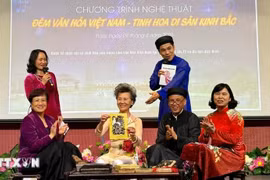 Introducing and demonstrating Dong Ho painting to the audience. (Photo: VNA)