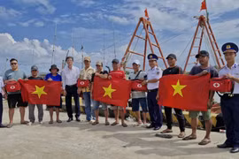 Personnel from the Vietnam Coast Guard Region 4 Command, in coordination with Ganh Hao commune, conduct a community outreach activity under the "Coast Guard Accompanies Fishermen" programme to raise awareness of combating illegal, unreported and unregulated (IUU) fishing. (Photo: VNA) 
