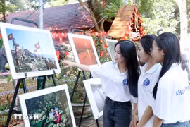 Students visit the photo exhibition. (Photo: VNA)