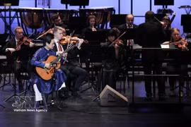 Guitarist Dang Ngoc Long performs with the Tübingen Symphony Orchestra (Germany) at the “A Rhapsody of Two Worlds” concert at Ho Guom Theatre in Hanoi in December 2025. (Photo: VNA)