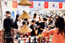 Visitors explore the Vietnamese booth. (Photo: VNA)