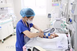A medical worker cares for a newborn baby. (Photo published by VNA)