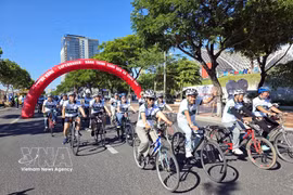 Delegates take part in a cycling event to promote a green lifestyle message. (Photo: VNA) 