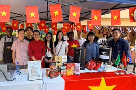 Staff members of the Vietnamese Embassy in Mozambique pose for a commemorative photo at the booth during the event. (Photo: VNA) 