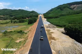 Contractors lay asphalt concrete on the roadbed of the Quy Nhon–Chi Thanh Expressway project. (Photo: VietnamPlus) 