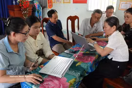 Members of the Phuong Quy 2 hamlet community digital technology team in Ngok Bay commune guides residents in submitting administrative applications online. (Photo: VNA) 